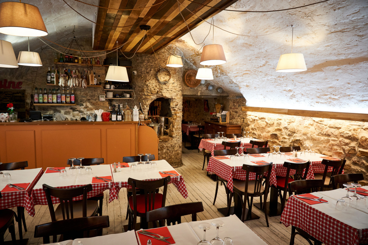 Salle voûtée aux murs de pierre et aux nappes à carreaux rouges